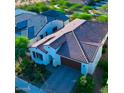 Aerial view of a single-story home featuring a terracotta roof, well-manicured landscaping, and an attached garage at 20363 W Coolidge St, Buckeye, AZ 85396