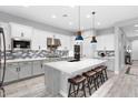 Modern kitchen with stainless steel appliances, a large island with seating, and stylish backsplash at 20363 W Coolidge St, Buckeye, AZ 85396