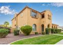 Two-story house with tan exterior, landscaping, and a walkway at 21525 E Camacho Rd, Queen Creek, AZ 85142