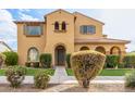 Two-story house with tan exterior, landscaping, and a walkway at 21525 E Camacho Rd, Queen Creek, AZ 85142