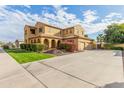 Two-story house with tan exterior, landscaping, and a driveway at 21525 E Camacho Rd, Queen Creek, AZ 85142