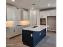 Modern kitchen featuring white cabinets, a dark blue island, and marble countertops at 2324 W Moody Trl, Phoenix, AZ 85041