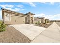 New construction home with a two-car garage and desert landscaping at 26448 W Kimberly Way, Buckeye, AZ 85396