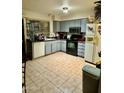 Galley style kitchen with grey cabinets and tiled floors at 2645 W Wolf St, Phoenix, AZ 85017