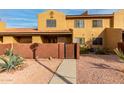 Tan two-story home with a gated entry and walkway at 3511 E Baseline Rd # 1203, Phoenix, AZ 85042