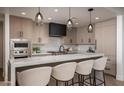 Modern kitchen with a large quartz island, custom cabinets, black hood, and stainless steel appliances at 7175 E Camelback Rd # 601, Scottsdale, AZ 85251