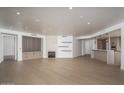 Spacious living room with hardwood floors, fireplace, and built-in shelving at 7175 E Camelback Rd # 601, Scottsdale, AZ 85251