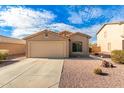 Tan house with a two-car garage and desert landscaping at 7244 S Sunrise Way, Buckeye, AZ 85326