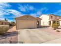 Tan house with a two-car garage and desert landscaping at 7244 S Sunrise Way, Buckeye, AZ 85326