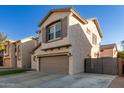 Two-story house with a gray garage door and a black fence at 9823 E Escondido Ave, Mesa, AZ 85208