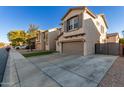 Two-story house with a gray garage door, artificial turf, and a black fence at 9823 E Escondido Ave, Mesa, AZ 85208