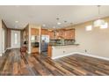 Kitchen with island, stainless steel appliances, and wood flooring at 20571 N Lemon Drop Dr, Maricopa, AZ 85138