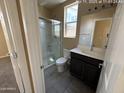 Bathroom featuring a shower and dark cabinets at 359 N 157Th Ln, Goodyear, AZ 85338