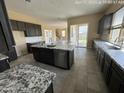 Spacious kitchen with granite countertops, stainless steel appliances, and dark cabinetry at 359 N 157Th Ln, Goodyear, AZ 85338