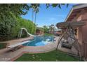 Inviting kidney-shaped pool with diving board, slide, and covered patio at 6316 E Monte Cristo Ave, Scottsdale, AZ 85254