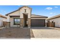 Modern house with a brown garage door and stone accents at 685 E Greenback Dr, San Tan Valley, AZ 85140