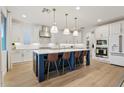 Modern kitchen with white cabinets, blue island, and quartz countertops at 9540 E Spiral Ave, Mesa, AZ 85212