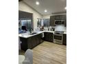 Modern kitchen with dark cabinets, white counters, and stainless steel appliances at 1223 E Villa Rita Dr, Phoenix, AZ 85022