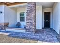 Covered front porch with brick columns and a sitting area at 14114 W Smoketree Dr, Surprise, AZ 85387