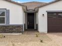 Close up front exterior featuring stacked stone and a dark wood door at 17691 W Southgate Ave, Goodyear, AZ 85338