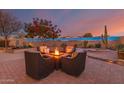 Evening view of backyard fire pit and seating area at 18109 W Juniper Dr, Goodyear, AZ 85338