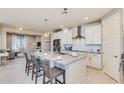 Modern kitchen with white cabinets, large island, and stainless steel appliances at 18202 W Cielo Grande Ave, Surprise, AZ 85387