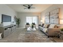 Living room with gray couch and large TV at 18972 W Woodlands Ave, Buckeye, AZ 85326