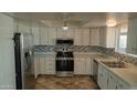 Renovated kitchen with white cabinets, stainless steel appliances, and tile backsplash at 2270 S Apache Dr, Apache Junction, AZ 85120