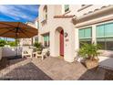 Inviting front patio with seating, umbrella, and potted plants at 4077 S Sabrina Dr # 24, Chandler, AZ 85248