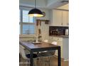 Bright kitchen with white cabinets, wood table, and modern pendant lighting at 4444 E Paradise Village N Pkwy # 107, Phoenix, AZ 85032