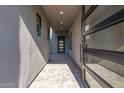 Light-filled covered entryway with modern glass and metal door at 5748 E Moura Dr, Cave Creek, AZ 85331