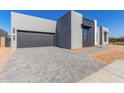 Contemporary home with gray facade and a paved driveway at 5748 E Moura Dr, Cave Creek, AZ 85331