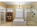 Elegant bathroom with soaking tub, walk-in shower, and a large window at 6210 W Foothill Dr, Glendale, AZ 85310