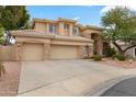 Tan two-story house with a three-car garage and landscaping at 6210 W Foothill Dr, Glendale, AZ 85310