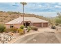 House exterior with three-car garage and desert landscaping at 15414 E Westridge Dr, Fountain Hills, AZ 85268