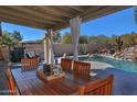 Covered patio with dining table and chairs, adjacent to the pool at 16060 N Boulder Dr, Fountain Hills, AZ 85268
