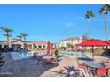 Community pool with red patio furniture and umbrellas at 1941 S Pierpont Dr # 1121, Mesa, AZ 85206