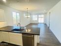 Bright living area with hardwood floors, stainless steel appliances, and sliding glass doors to the backyard at 7802 E Quintana Ave, Mesa, AZ 85212
