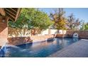 Inviting pool with brick coping and water features at 8280 S Pecan Grove Cir, Tempe, AZ 85284