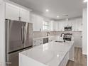 Modern kitchen with white shaker cabinets, quartz countertops, and stainless steel appliances at 10662 S 297Th Ave, Palo Verde, AZ 85343