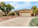 Tan stucco house with tile roof, desert landscaping, and a two-car garage at 11664 E Caron St, Scottsdale, AZ 85259