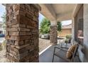 Inviting front porch with stone pillars and comfortable seating at 11860 W Grant St, Avondale, AZ 85323