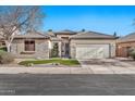 Single-story home with neutral exterior, two-car garage, and well-manicured lawn at 11930 W Monroe St, Avondale, AZ 85323