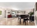 Spacious living room with a grand piano and tile floors at 13438 W Ashwood Dr, Sun City West, AZ 85375