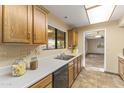 Kitchen features wood cabinets, tile flooring and stainless steel dishwasher at 19806 N Stardust Blvd, Sun City West, AZ 85375