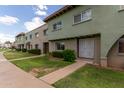 Exterior view of multiple townhomes with a walkway and green space at 225 N Standage -- # 122, Mesa, AZ 85201