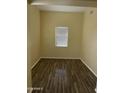 Well-lit bedroom with hardwood-style flooring and neutral wall colors at 2431 N 83Rd Dr, Phoenix, AZ 85037