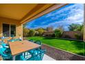 Covered patio with seating area overlooking a spacious grassy backyard at 25719 N 54Th Dr, Phoenix, AZ 85083