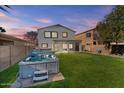 Spacious backyard with a hot tub, grass, and a covered patio at 29061 N Cactus Cir, San Tan Valley, AZ 85143