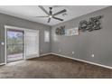 Bright bedroom with carpet flooring, sliding door to balcony and ceiling fan at 3935 E Rough Rider Rd # 1076, Phoenix, AZ 85050